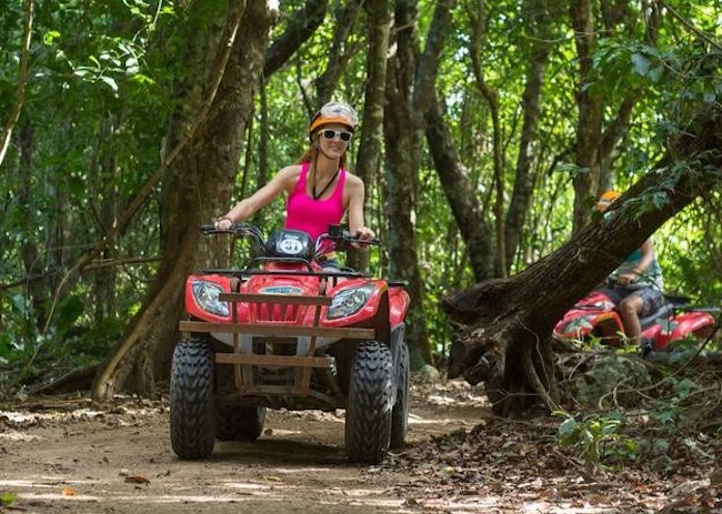 Charlotte watching nature while driving an ATV in Cozumel.