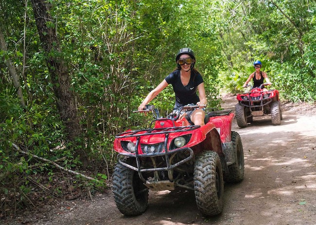Nina and her sister driving an ATV in Cozumel.